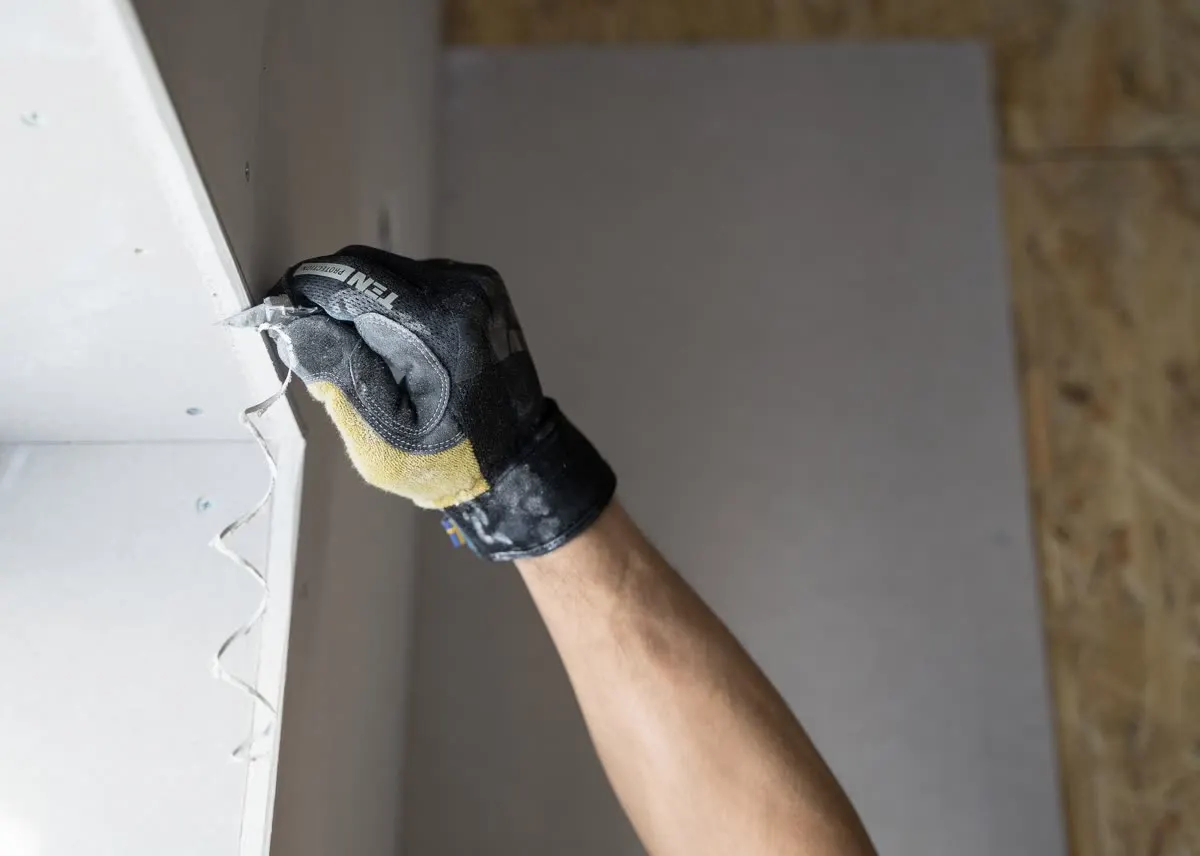 A drywall corner being skimmed and finished by hand