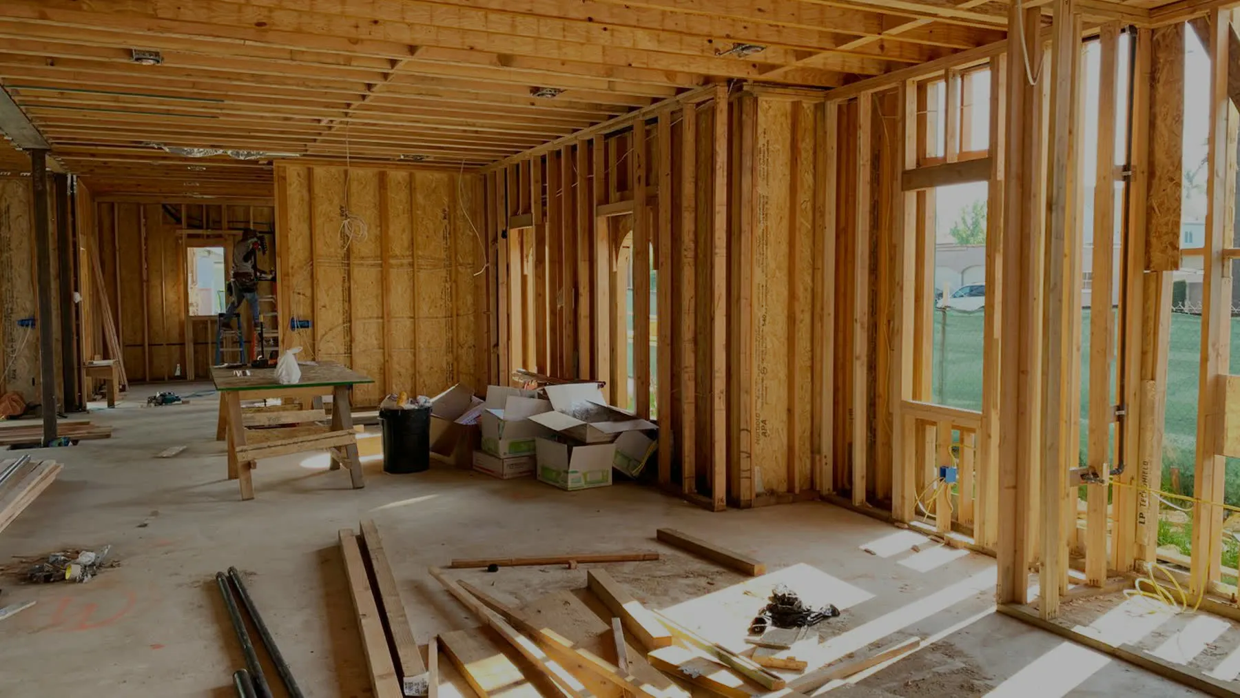 A house interior at the framing stage, studs and joists open to daylight